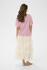 Woman wearing a pink top and white tulle skirt on a white background
