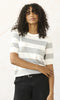 Woman wearing a striped sweater and black pants on a white background