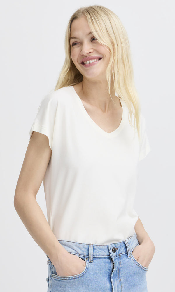 Woman wearing a white t-shirt and blue jeans on a plain background