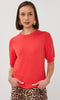 Woman wearing a red sweater with a plain background