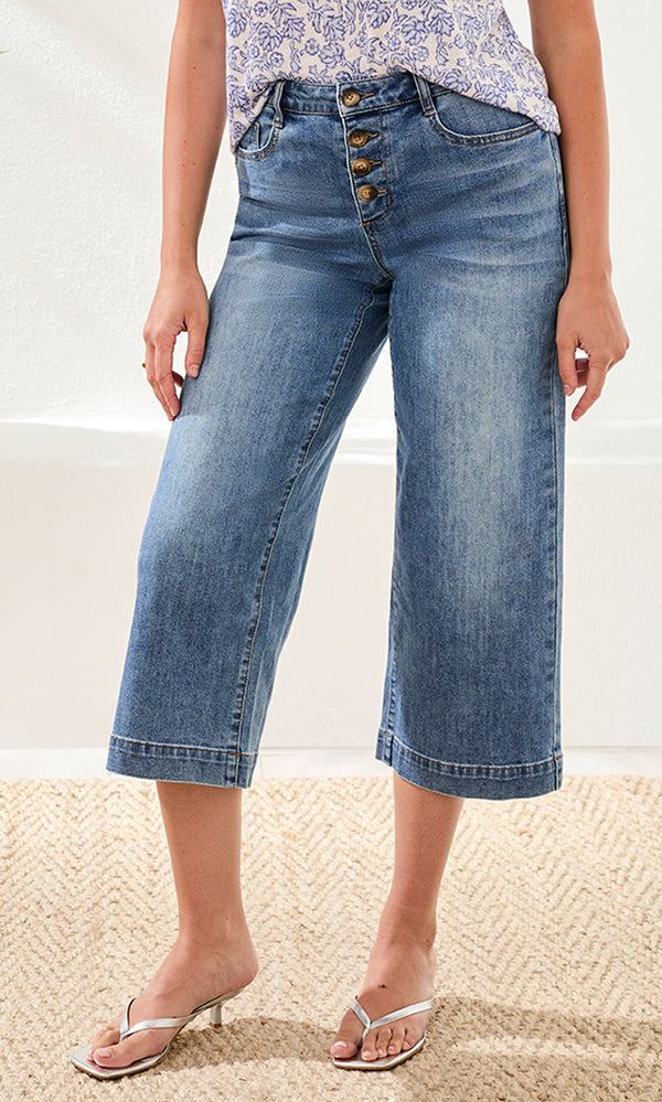 Woman wearing blue denim wide-leg jeans on a neutral background