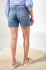 Person wearing blue denim shorts on a white background
