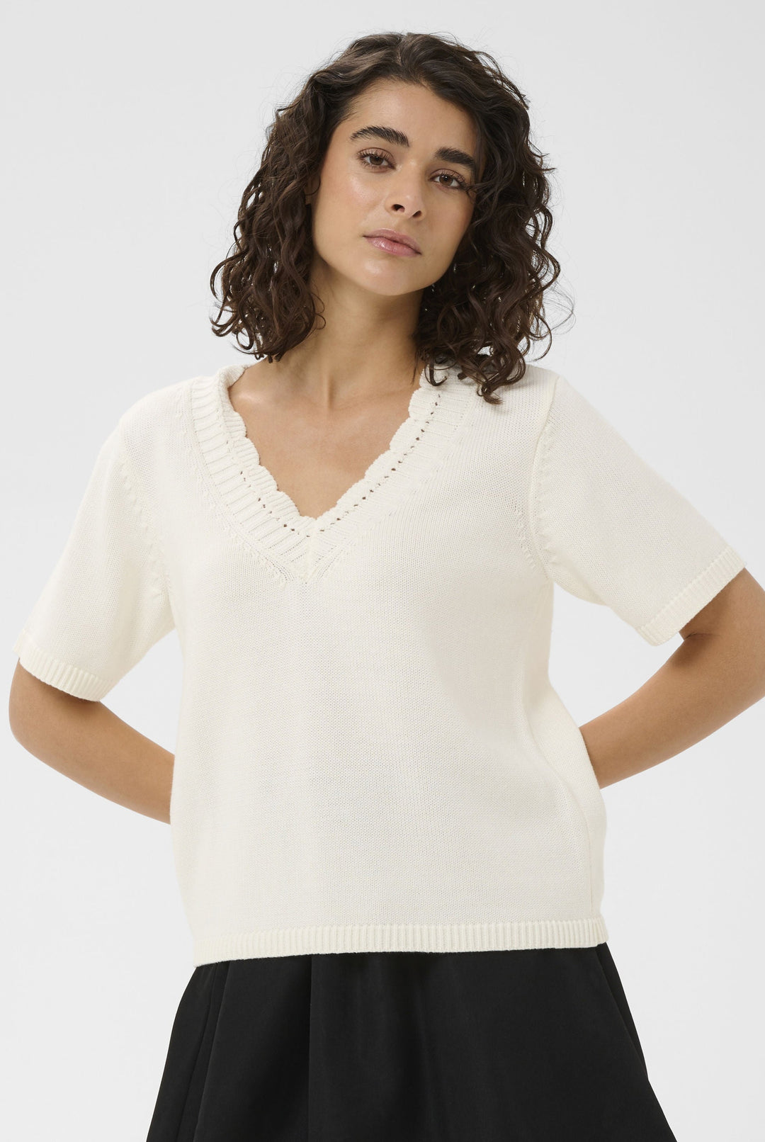 Woman wearing a white top and black skirt on a white background