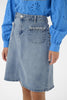 Person wearing a blue denim skirt and blue blouse with intricate designs.