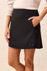 Person wearing a black skirt with a neutral background