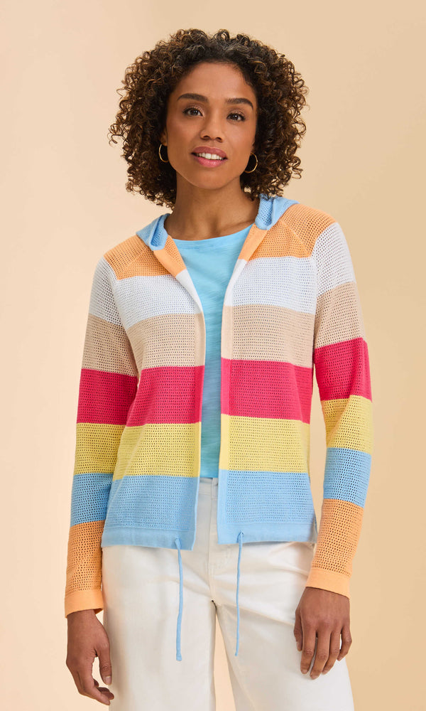 Woman wearing a colorful striped cardigan against a beige background