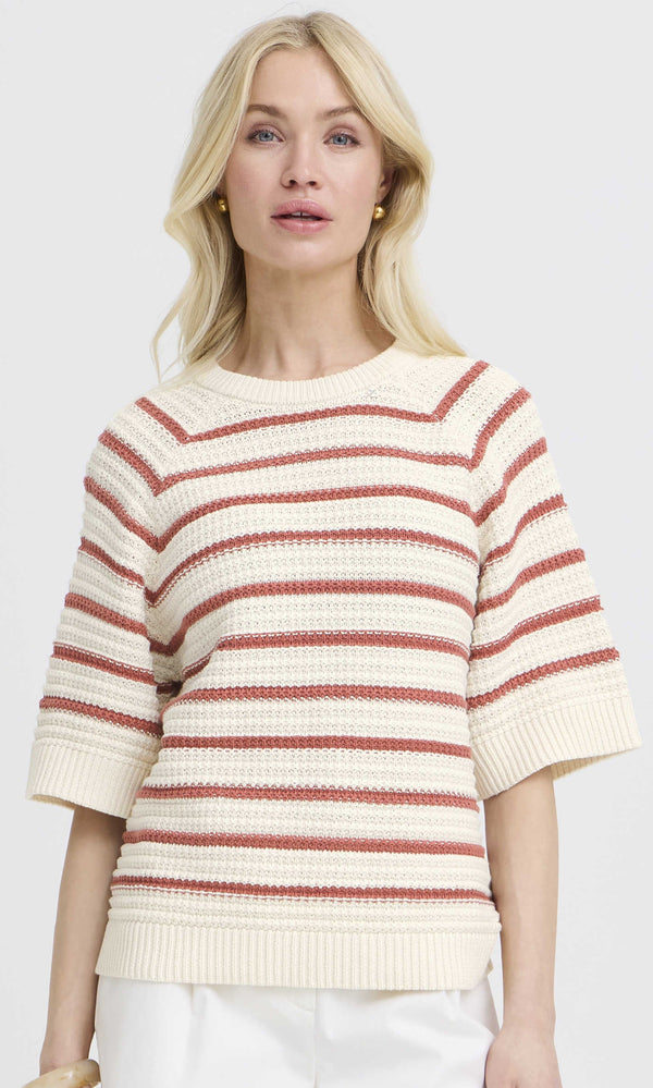 Woman wearing a striped sweater with a plain background