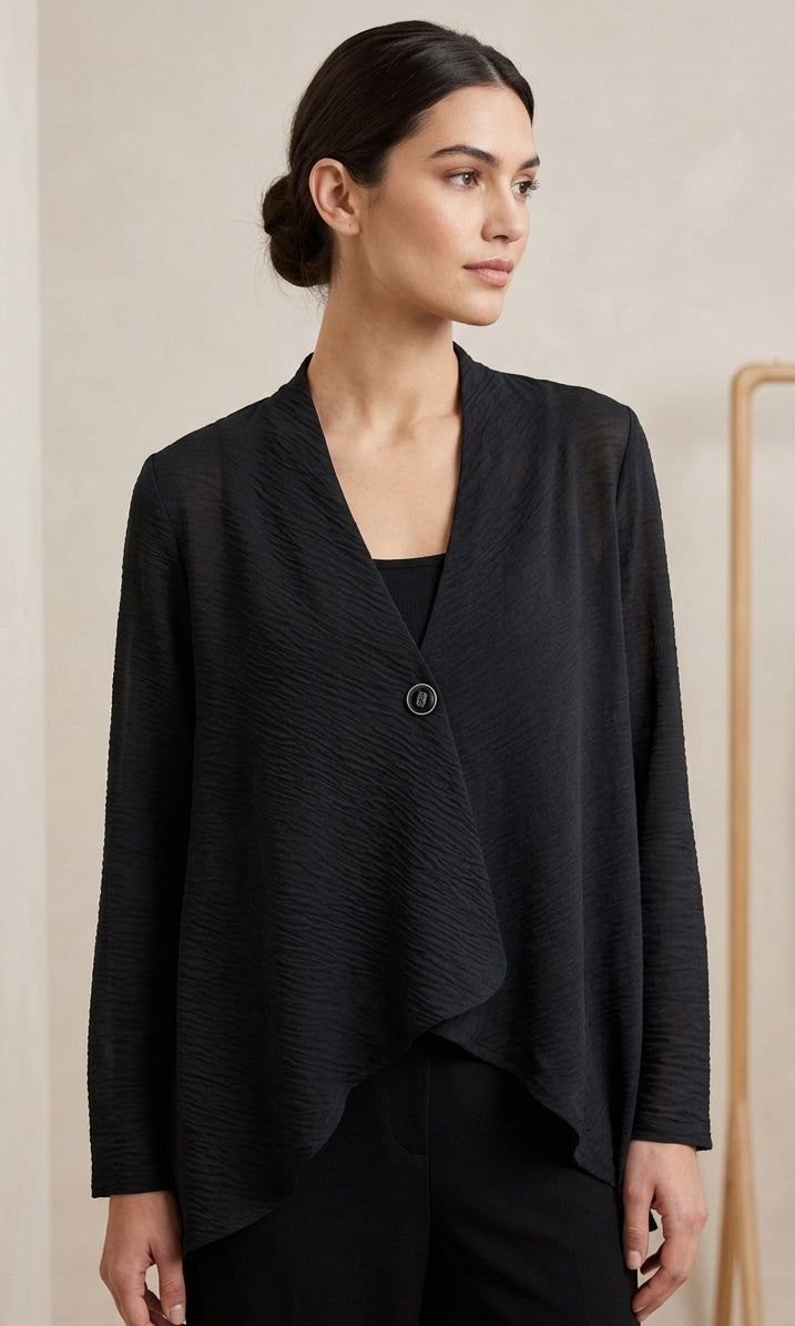 Woman wearing a black jacket against a beige background