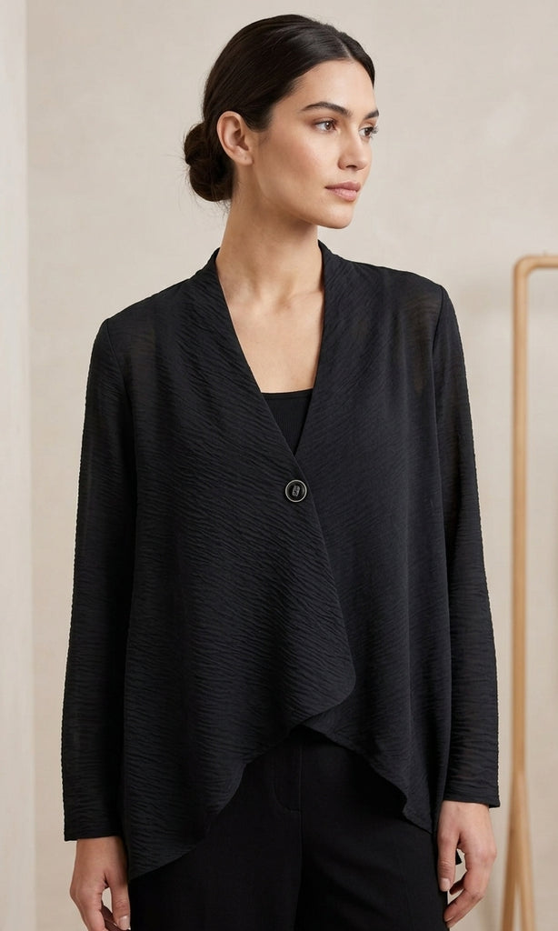 Woman wearing a black jacket against a beige background