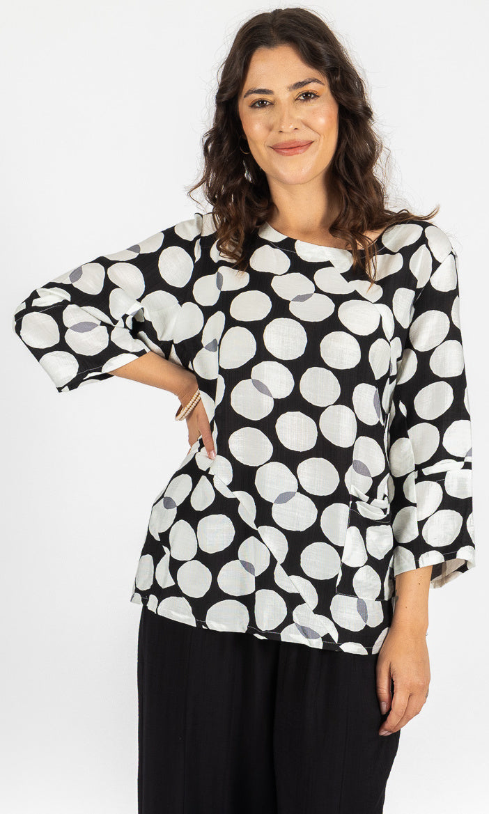 Woman wearing a black and white polka dot blouse on a white background