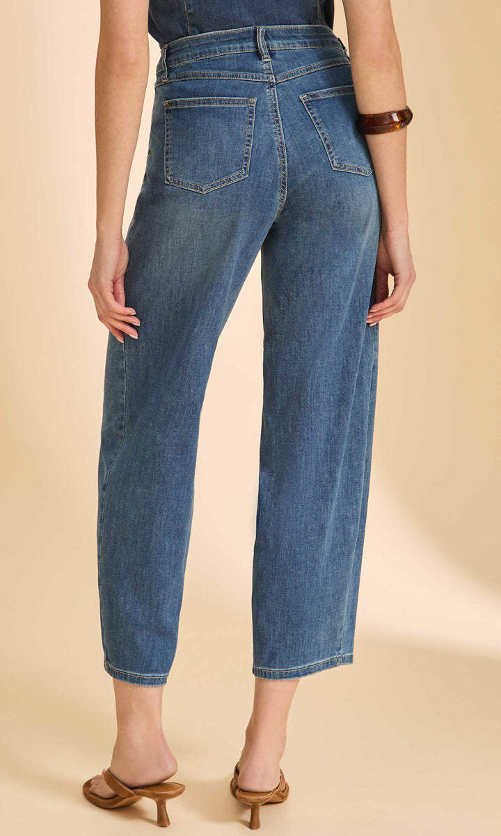 Person wearing blue jeans on a beige background