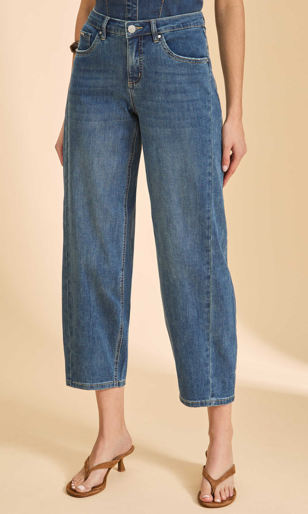 Person wearing blue jeans on a beige background