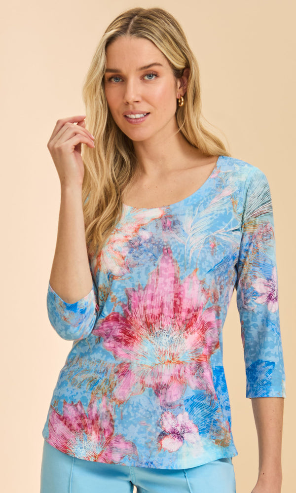 Woman wearing a colorful floral blouse against a beige background