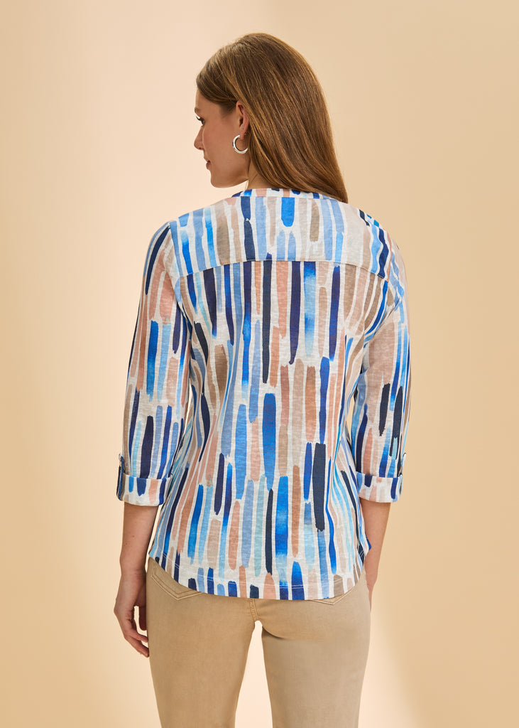 Woman wearing a colorful patterned shirt against a beige background
