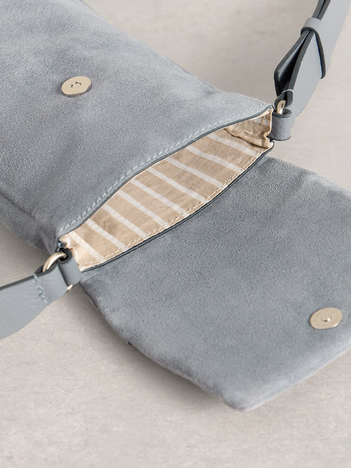 Gray suede handbag with beige interior on a light gray background