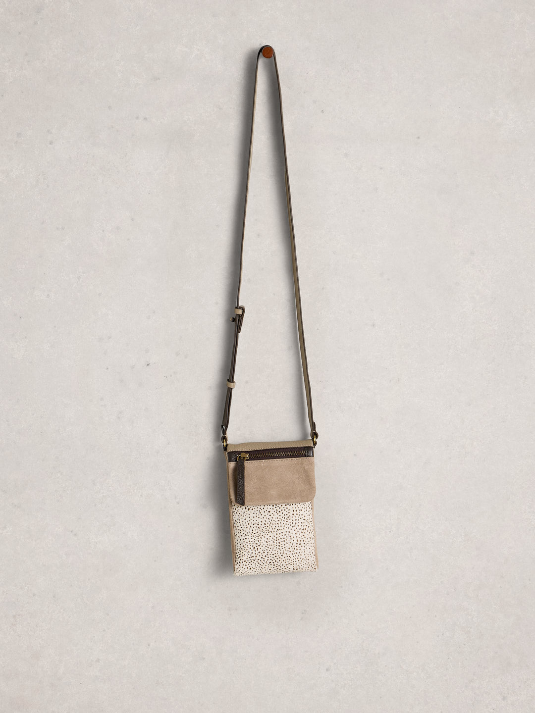 Small crossbody bag with textured surface on a light gray background
