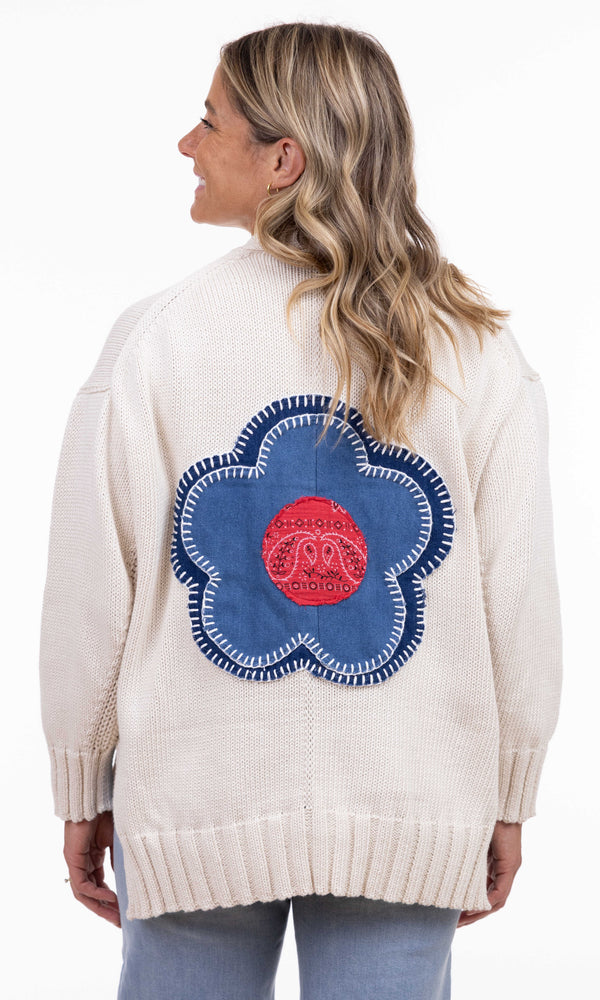 Beige knit button-front cardigan with red bandana pockets and a denim flower patch on the back