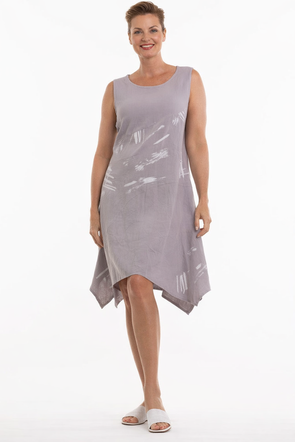 Woman wearing a sleeveless, light gray dress with white abstract patterns on a white background