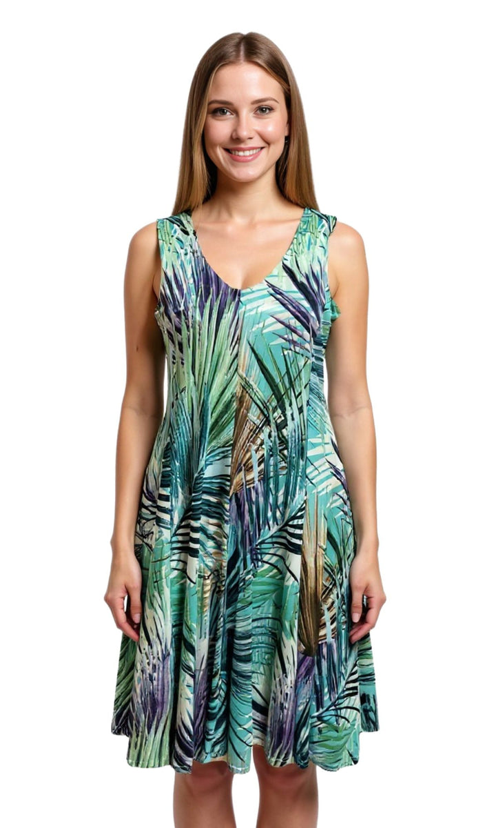Woman wearing a sleeveless dress with a tropical leaf pattern on a white background