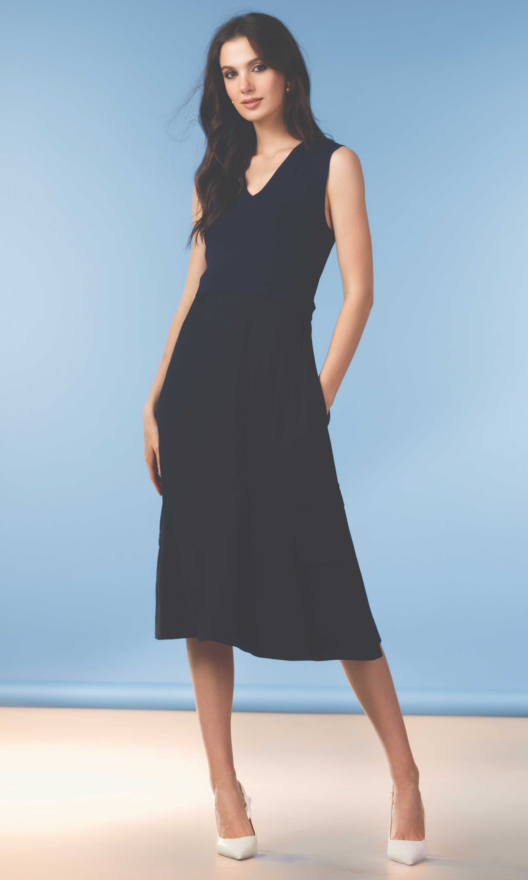 Woman wearing a navy blue dress against a light blue background