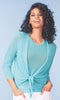 Woman wearing a light blue cardigan with a knot detail against a light blue background