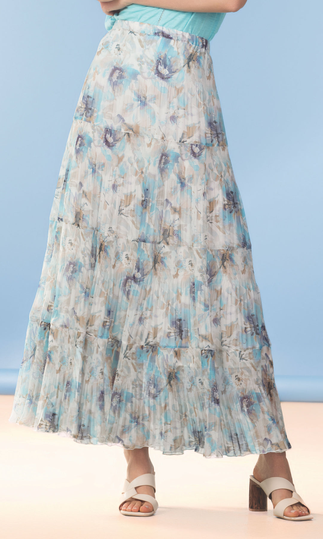 Woman wearing a floral skirt on a beach with a blue sky background
