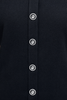 Close-up of a black shirt with white buttons on a dark background