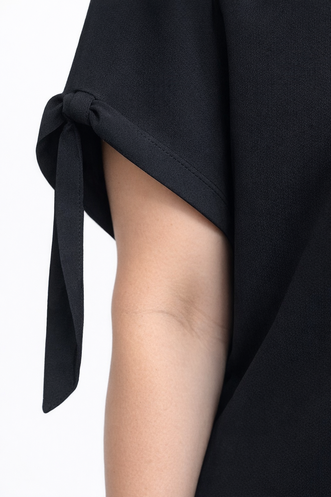 Black dress with a tie detail on a white background