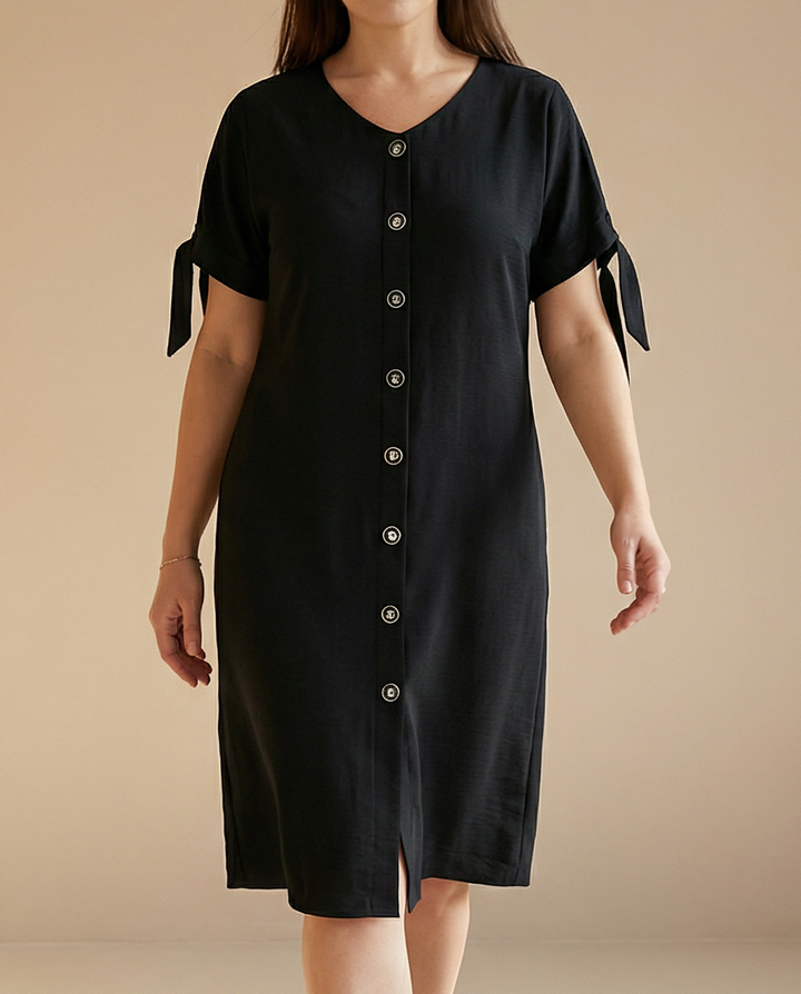 Black dress with tied sleeves worn by a person on a beige background