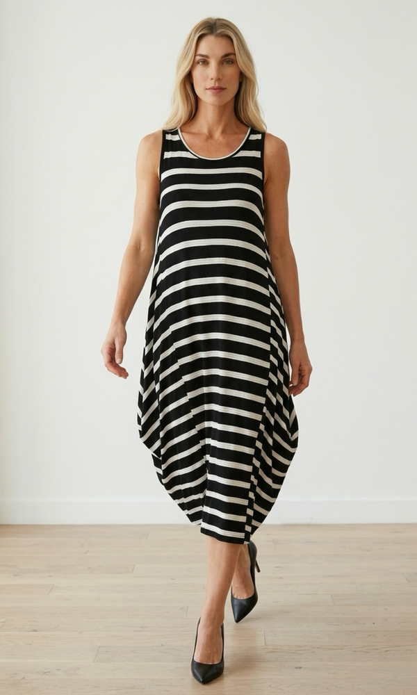 Woman wearing a black and white striped dress against a plain background