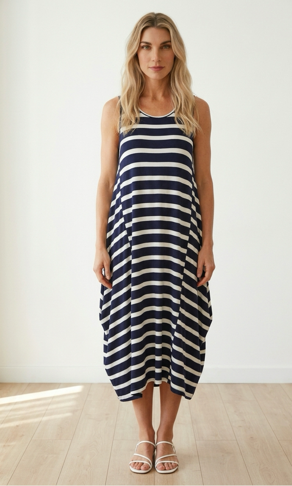 Woman wearing a navy and white striped dress in a minimal indoor setting