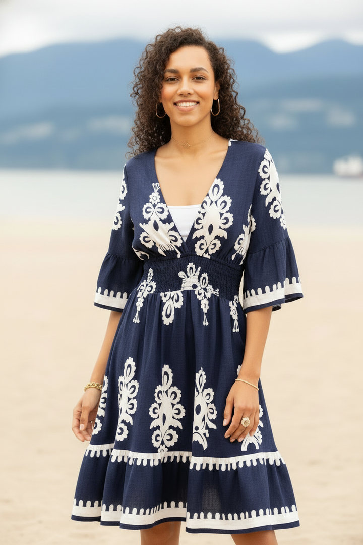Woman wearing a navy dress with white patterns on a beach