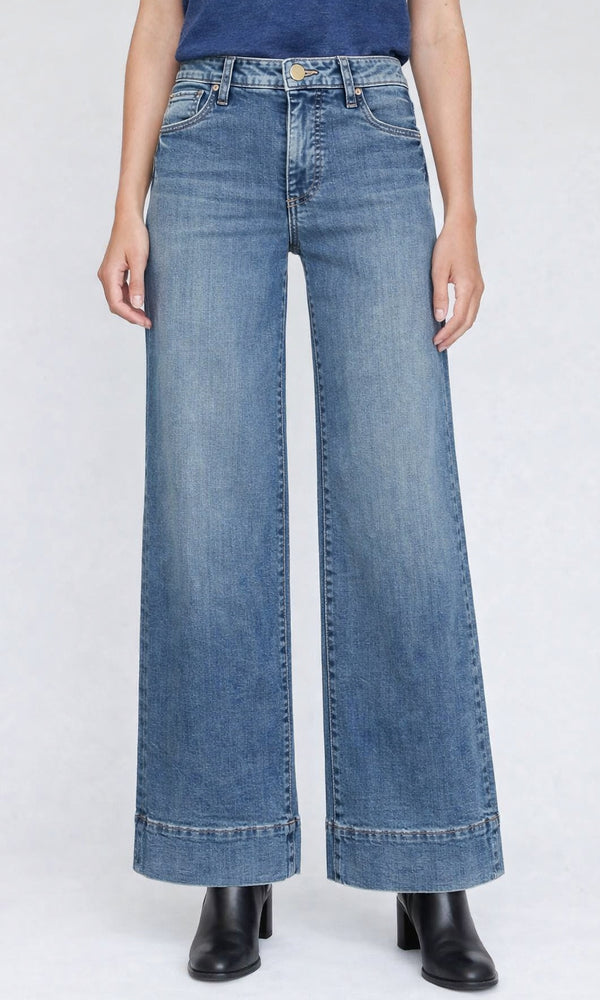 Person wearing light blue wide-leg jeans on a white background