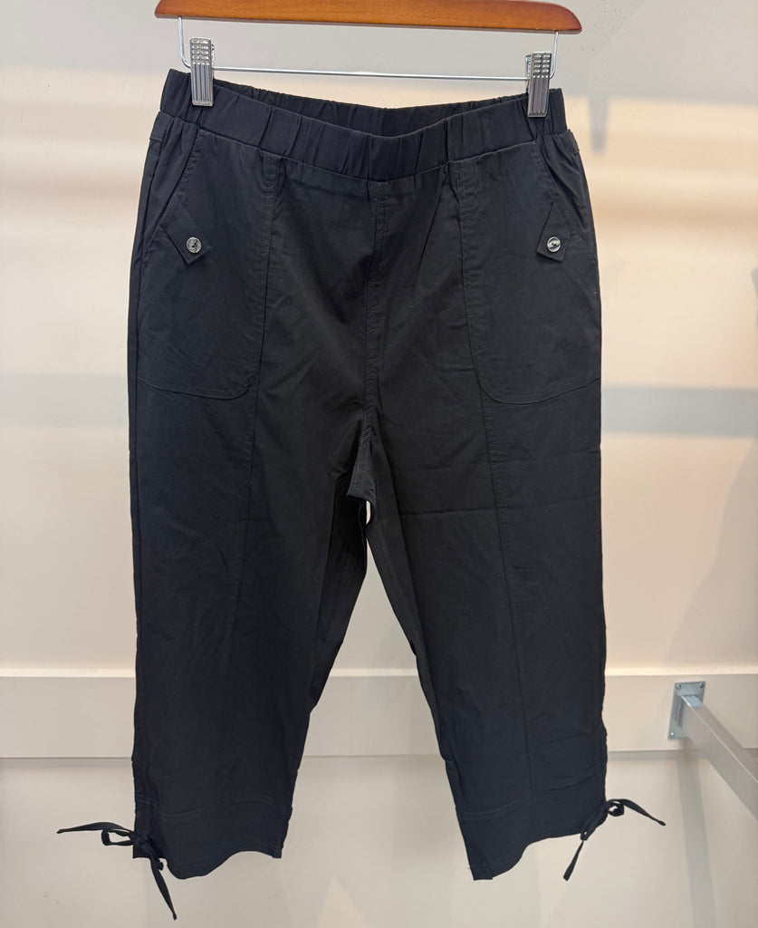 Black pants hanging on a rack against a white background