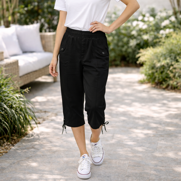 Person wearing black capri pants and white sneakers in an outdoor setting