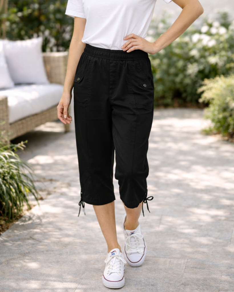 Person wearing black capri pants and white sneakers in an outdoor setting