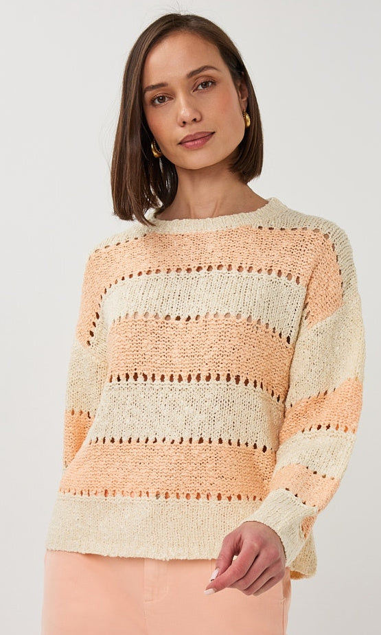 Woman wearing a striped sweater against a plain background