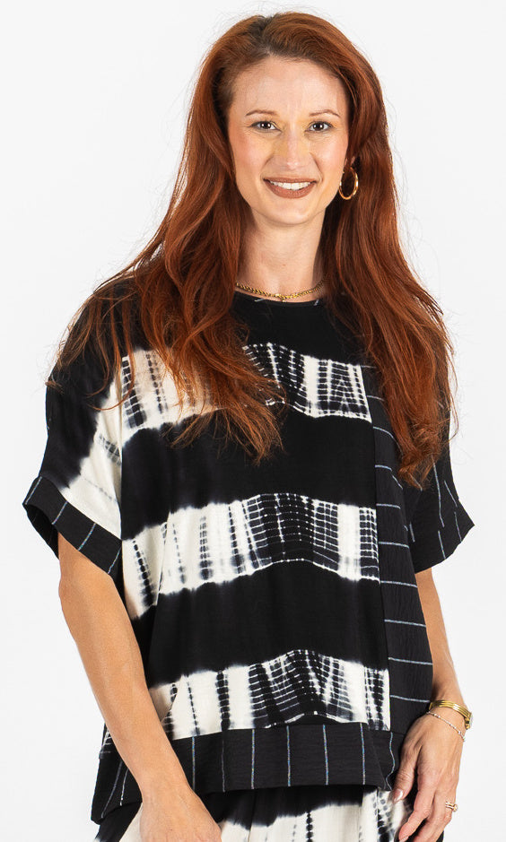 Woman wearing a black and white patterned top on a white background