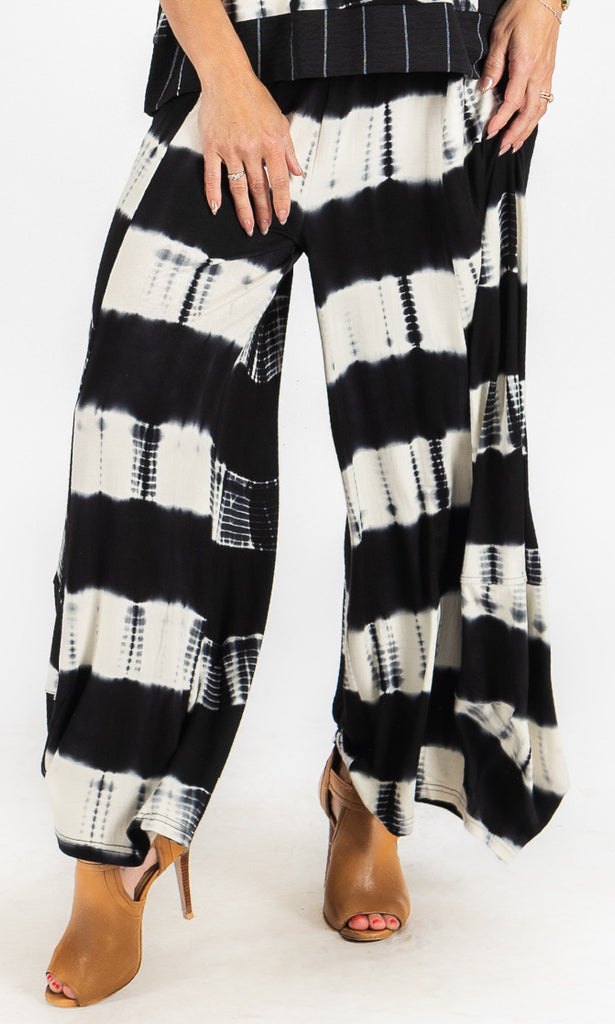 Black and white tie-dye pants worn by a person on a white background