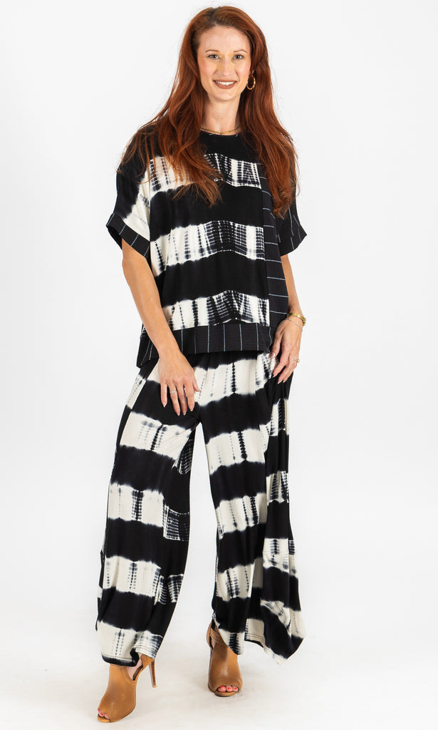 Woman wearing a black and white patterned outfit on a white background