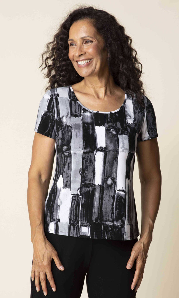 Woman wearing a black and white patterned top against a beige background