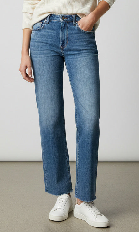 Model wearing high rise straight leg denim jeans with raw hem and classic five pocket styling.