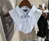 Light blue collared shirt on a hanger with a blurred background