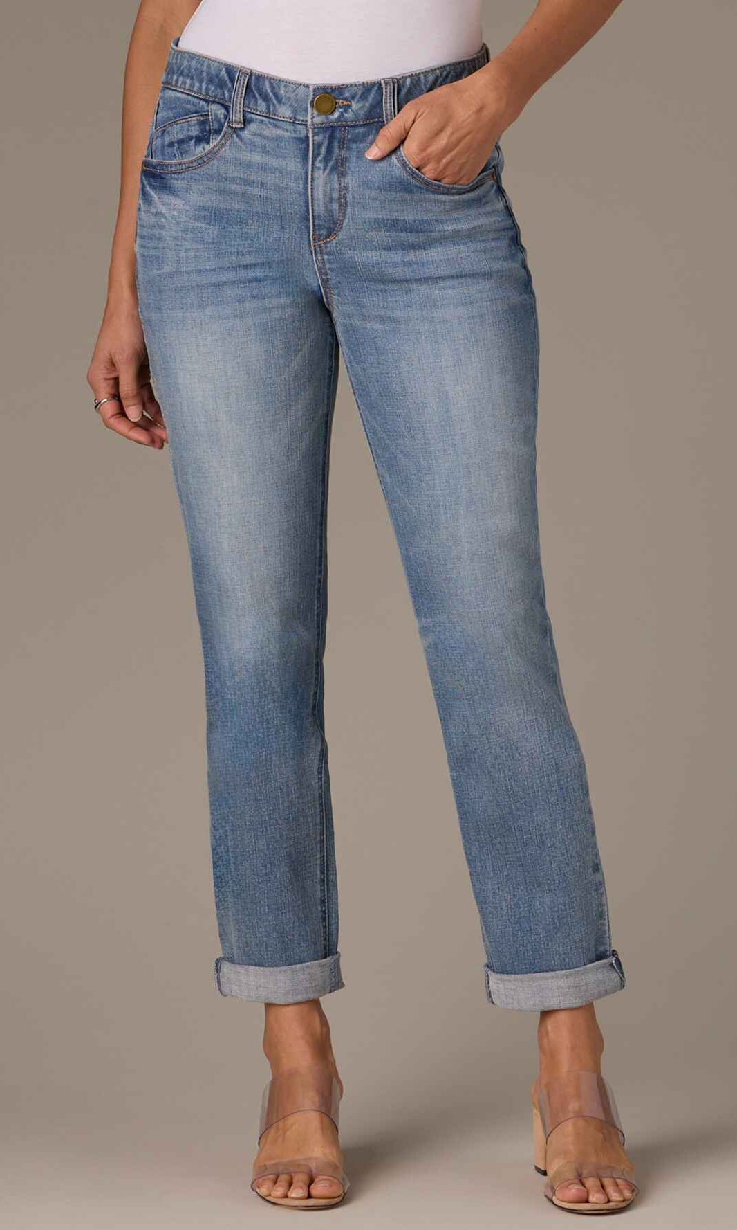 Person wearing light blue jeans on a neutral background