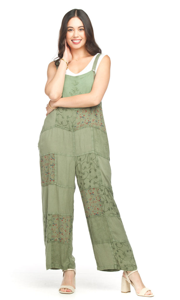 Woman wearing a green lace jumpsuit on a white background