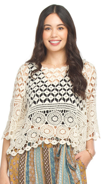 Woman wearing a crochet top with a white background