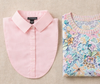 Pink shirt and floral patterned fabric on a beige background