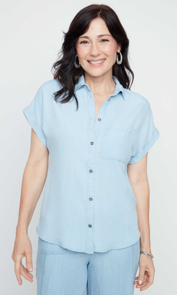 Woman wearing a light blue shirt and pants on a white background