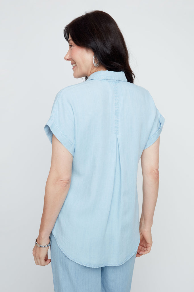 Woman wearing a light blue shirt against a white background