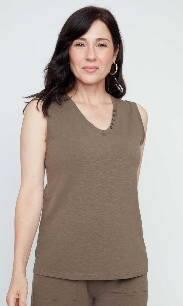 Woman wearing a brown sleeveless top and shorts on a white background